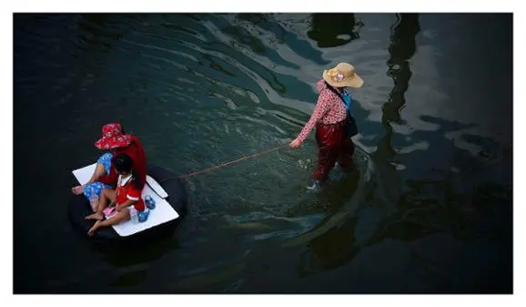 La femme de La Mo le tirait de la même façon que cette mère transporte sa fille sur l'eau.